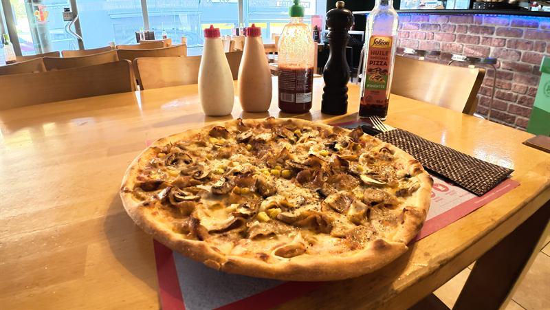 Frisch gebackene Pizza auf dem Tisch im Gastraum